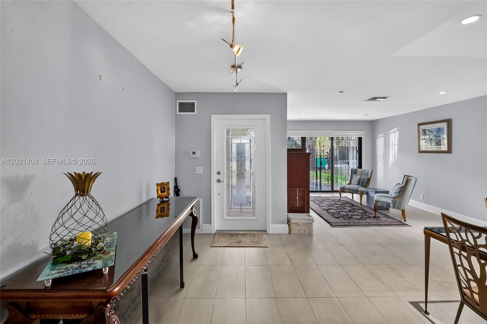 A bright entryway features light tile floors, a glass-paneled front door, and a console table — 8887 SW 62nd Ter # A, Miami FL 33173, MIAMI, FL
