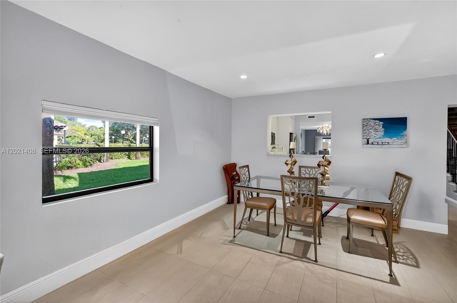 A dining room features a glass-top table, decorative chairs, light tile flooring, and a window — 8887 SW 62nd Ter # A, Miami FL 33173, MIAMI, FL