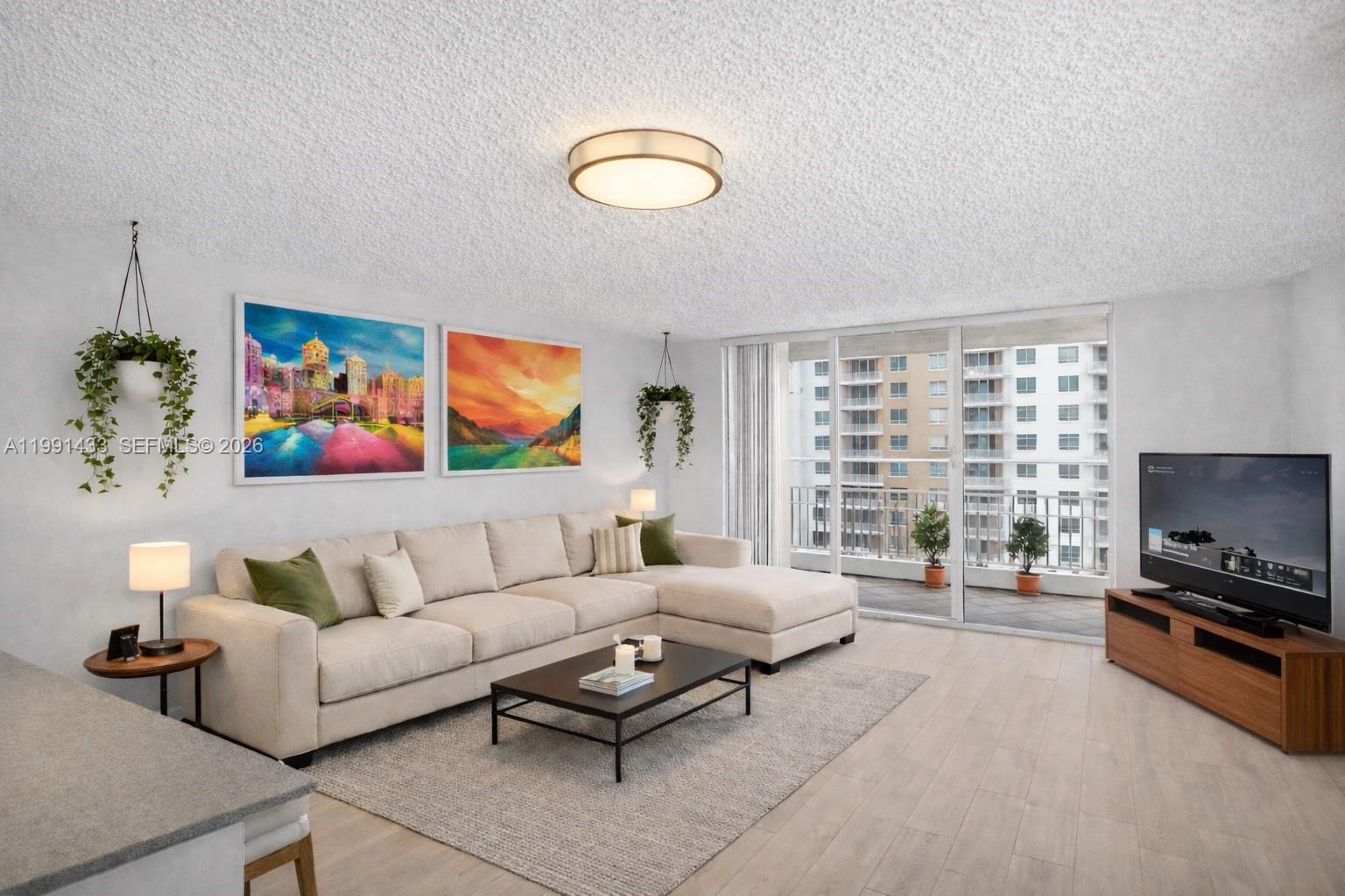 A living room features a beige sectional sofa, a coffee table, and a balcony view — 701 Brickell Key Blvd # 1108, Miami FL 33131, MIAMI, FL