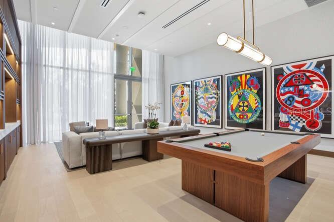 A modern lounge features a pool table, a long sofa, and colorful wall art — 3015 S YSABELLA AVENUE UNIT 601, TAMPA, FL