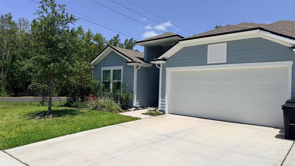 A blue house with a white garage door and a concrete driveway — 5 PECAN RIDGE COURT, JACKSONVILLE, FL