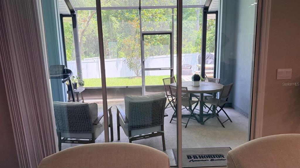A screened-in patio features outdoor furniture and a view of a fenced backyard — 5 PECAN RIDGE COURT, JACKSONVILLE, FL