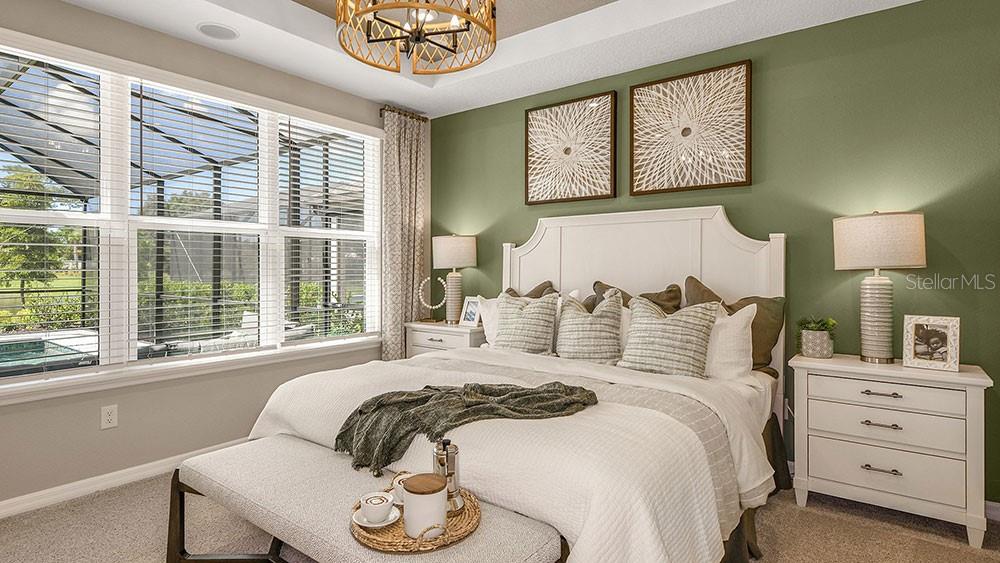 A bedroom features a white bed, green accent wall, two nightstands, and a large window — 763 STEEL DRIVE, APOLLO BEACH, FL