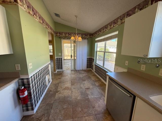 A kitchen with tile flooring, green walls, plaid wallpaper, and a sliding glass door — 17760 SE 91ST FREEDOM COURT, THE VILLAGES, FL