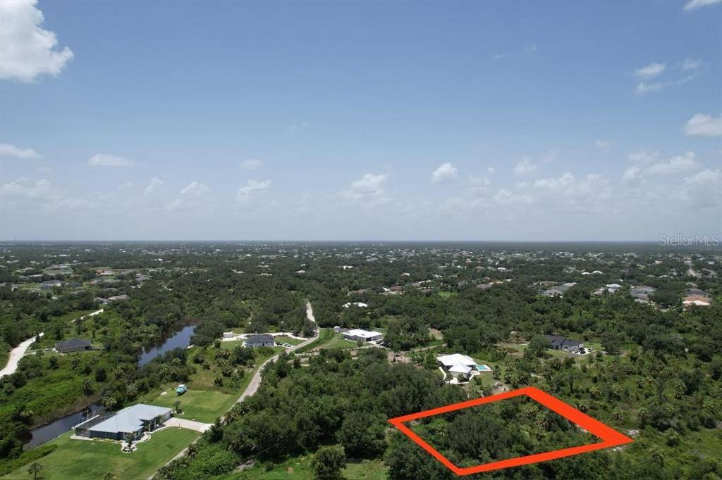 An aerial view shows a wooded lot outlined in red within a rural residential area — 1232 HARBOUR SUNSET COURT, PUNTA GORDA, FL