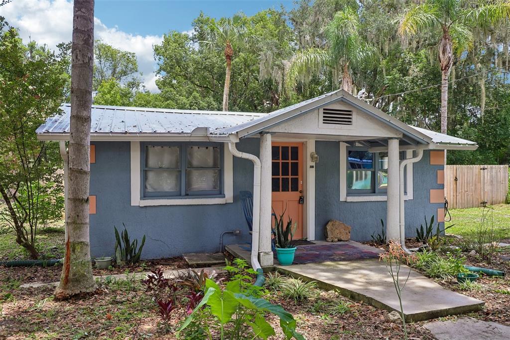 A small, blue, single-story house with a metal roof and a peach-colored front door — 521 S 9TH STREET, CRESCENT CITY, FL