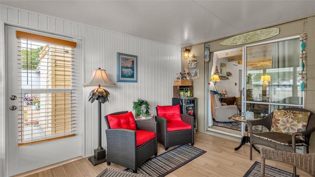 A sunroom features wicker chairs with red cushions, a bar area, and sliding glass doors — 5109 CLUB CIRCLE, LAKE WALES, FL