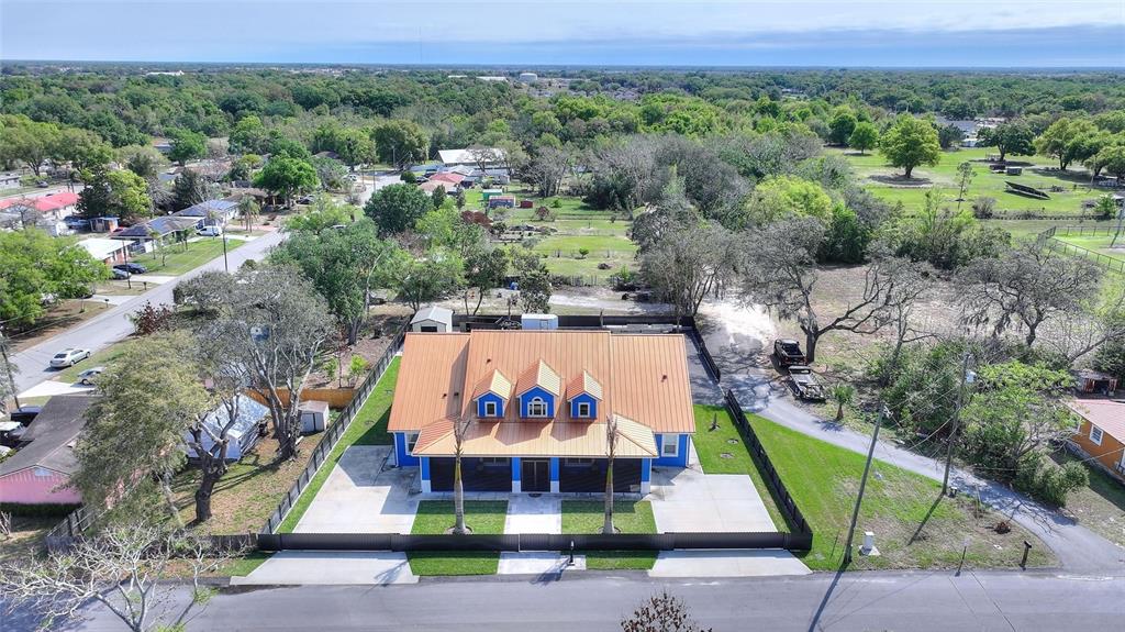An aerial view shows a blue house with a metal roof and three dormer windows — 803 N 24TH STREET, HAINES CITY, FL