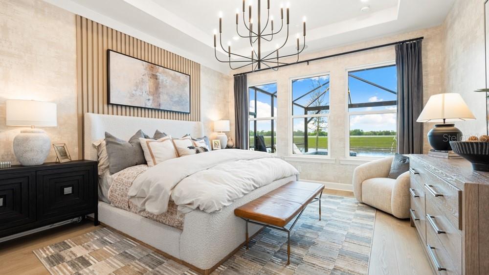 A bedroom features a textured accent wall, a chandelier, and windows overlooking a screened patio — 14236 DUNLIN AVENUE, PUNTA GORDA, FL