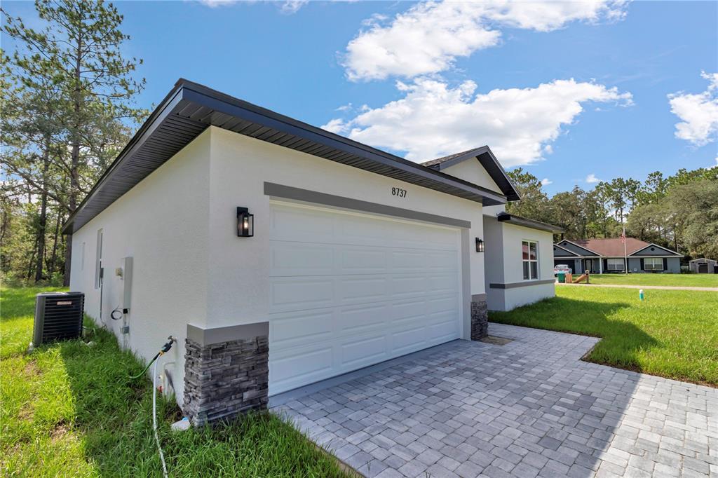 A modern bathroom features a double vanity, a freestanding tub, and light wood-look flooring — 8737 N RAIDIN DRIVE, CITRUS SPRINGS, FL