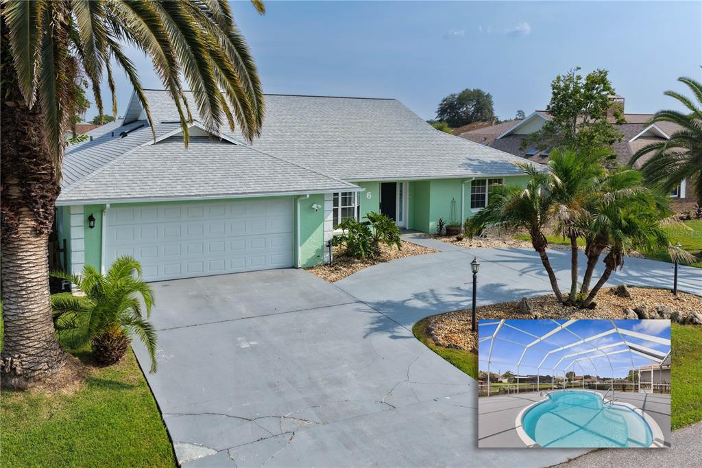 A light green house with a gray roof, a two-car garage, and an inset pool — 6 CHERRY COURT, PALM COAST, FL