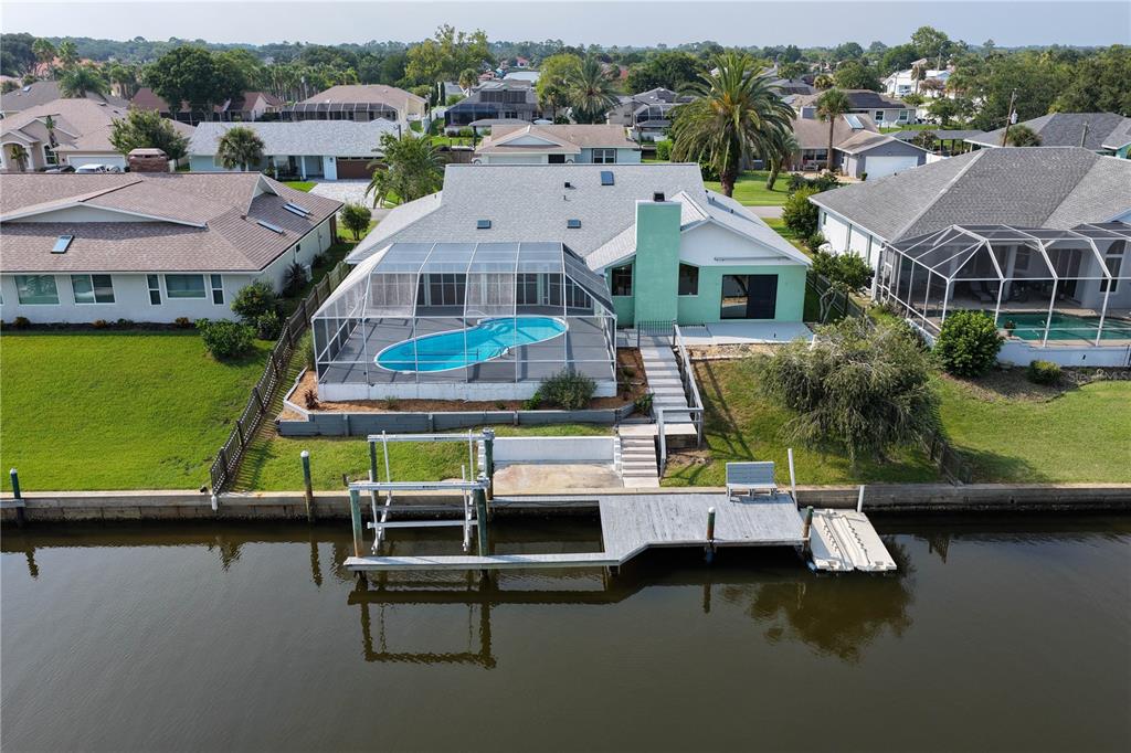 An aerial view shows a waterfront house with a screened pool and a private boat dock — 6 CHERRY COURT, PALM COAST, FL