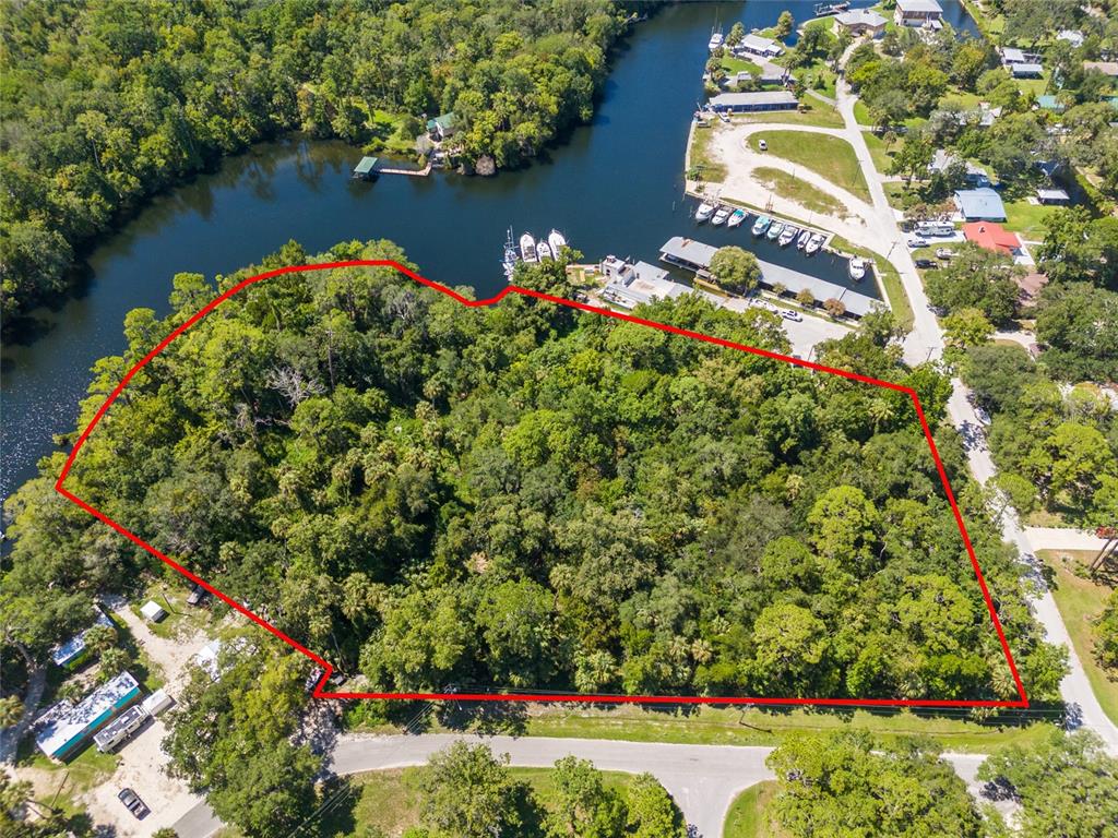 An aerial view shows a wooded lot outlined in red next to a river — 0 HICKORY AVENUE, YANKEETOWN, FL