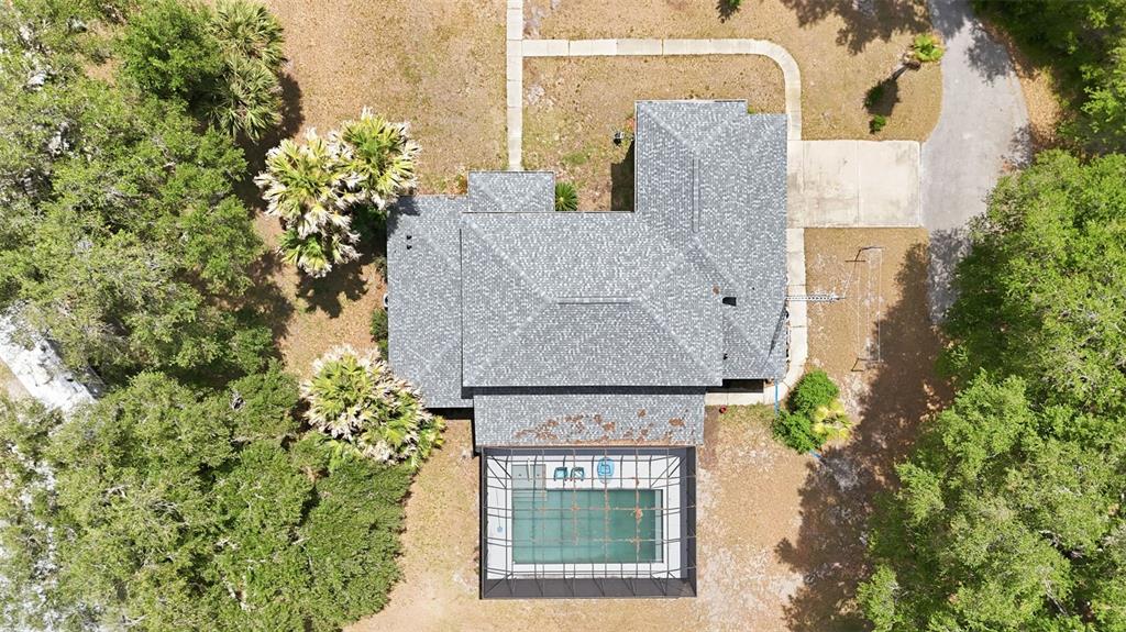 An aerial view shows a house with a gray shingled roof and a screened-in pool — 10639 SE SUNSET HARBOR ROAD, SUMMERFIELD, FL