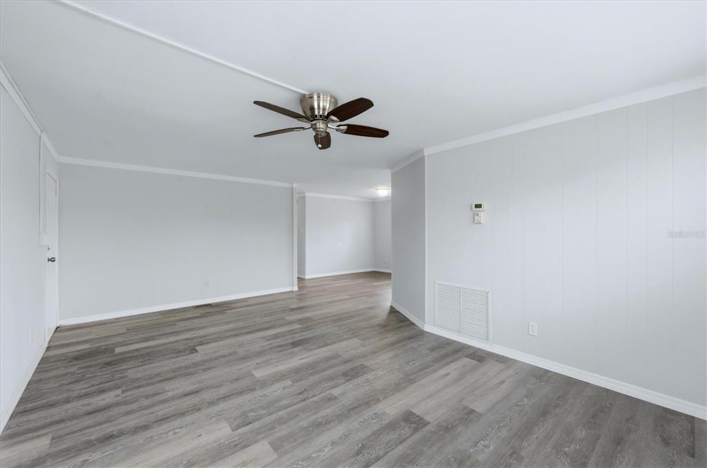 An empty room with light gray walls, wood-look flooring, and a ceiling fan — 3310 BLUE JAY LANE, ENGLEWOOD, FL