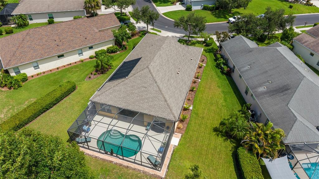 An aerial view shows a house with a screened-in pool and solar roof panels — 11739 FENNEMORE WAY, PARRISH, FL