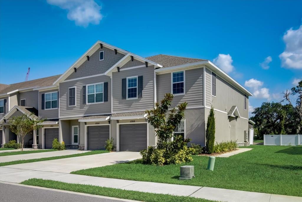 A two-story townhouse with gray siding, a shingled roof, and attached garages — 10916 QUICKWATER COURT, RIVERVIEW, FL
