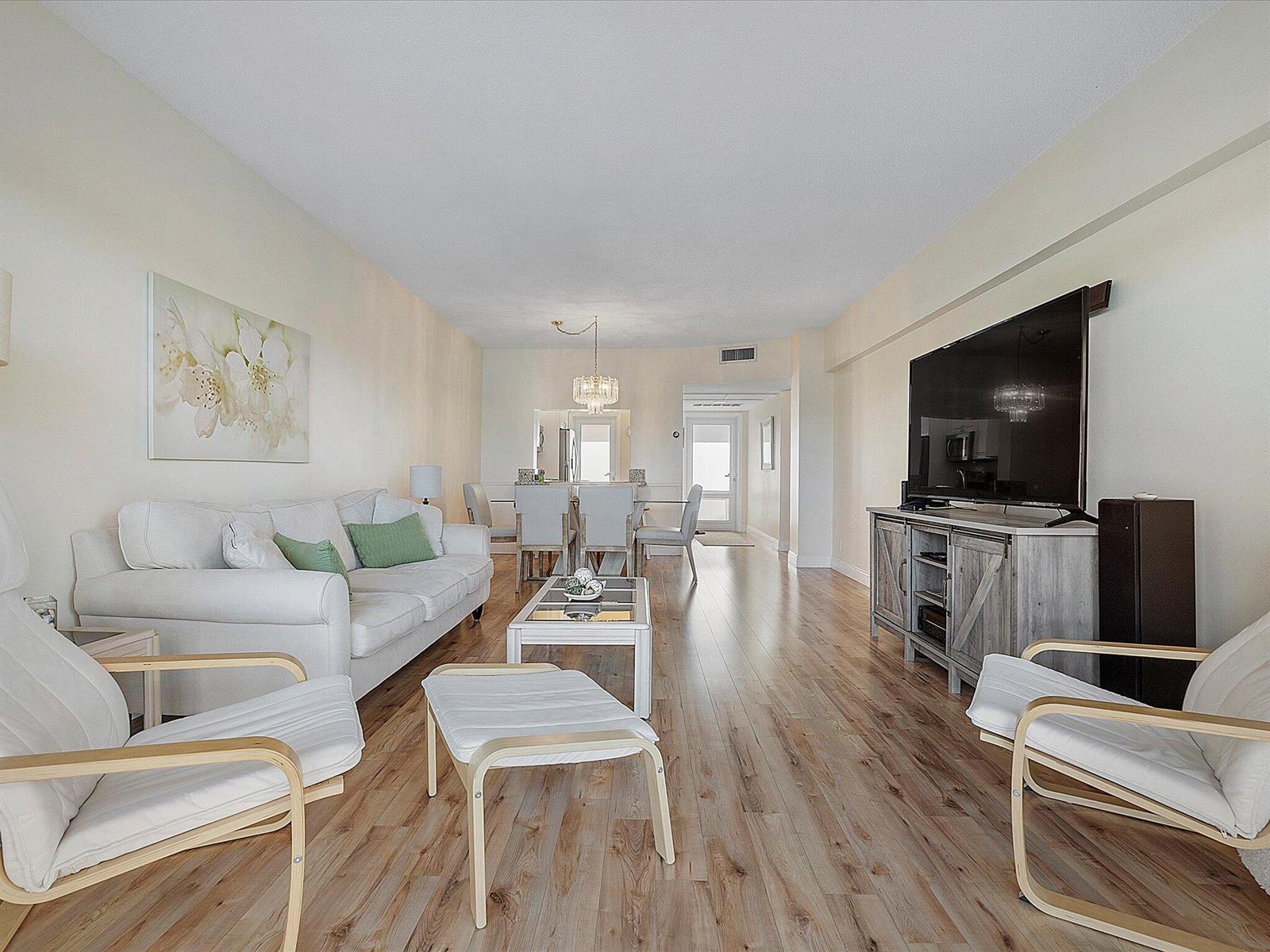 A living room with light wood floors, a white sofa, and a television on a console — 1481 S Ocean Boulevard # 315a, Pompano Beach FL 33062, POMPANO BEACH, FL