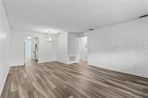 An open living area features light-colored wood-look flooring and white walls — 5257 81ST LANE N UNIT 17, ST PETERSBURG, FL