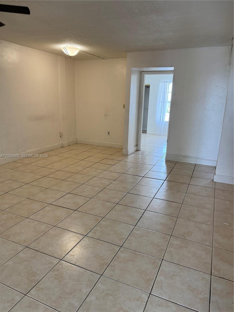 An empty room features light-colored floor tiles, white walls, and a doorway leading elsewhere — 7105 W 13th Ave # 403, Hialeah FL 33014, HIALEAH, FL