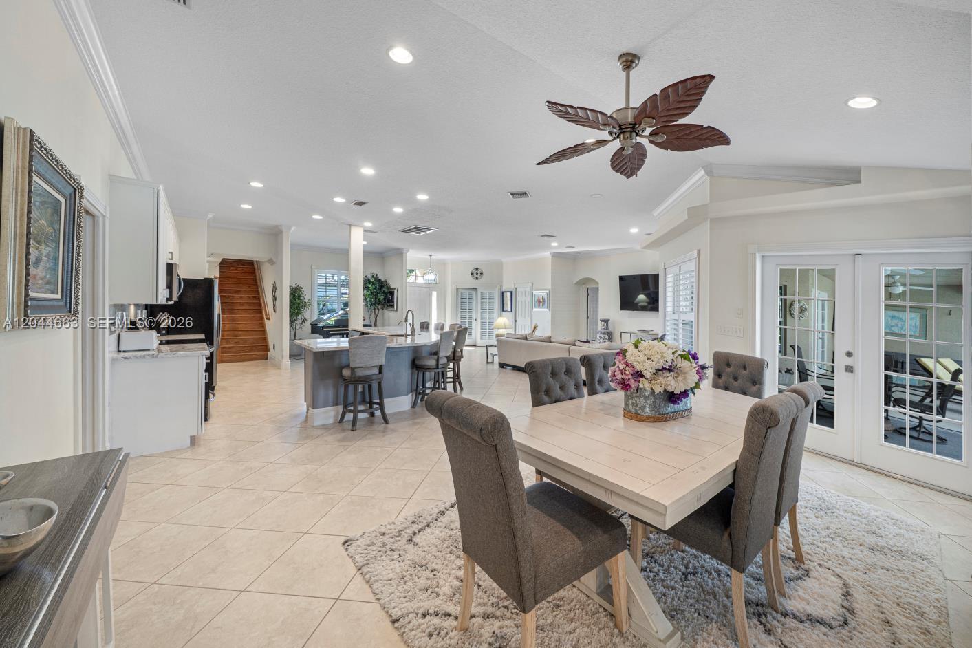 An open-concept kitchen, dining area, and living room featuring tile floors and a ceiling fan — 5220 Rosewood Ln, Vero Beach FL 32966, VERO BEACH, FL