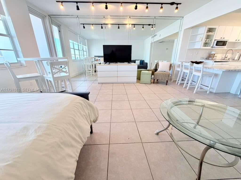 A studio apartment features a bed, a living area with a television, and a kitchen — 100 Lincoln Rd # 1220, Miami Beach FL 33139, MIAMI BEACH, FL