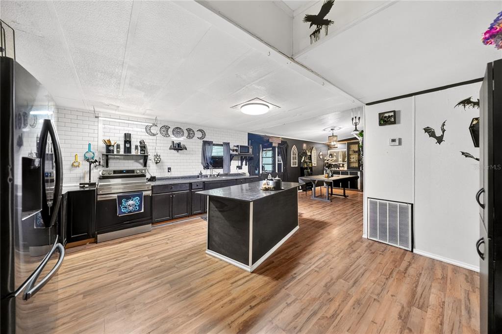 A kitchen with black cabinets, a central island, and white subway tile backsplash — 43110 E 4TH STREET, PAISLEY, FL