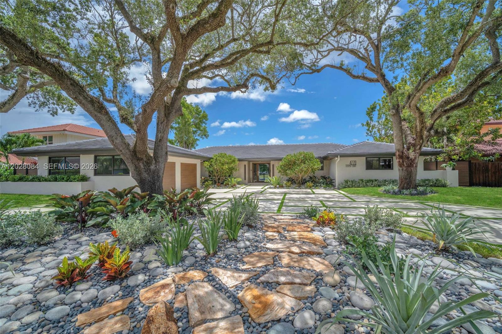 A single-story house with a stone walkway, large oak trees, and a paved driveway — 4220 Casper Ct, Hollywood FL 33021, HOLLYWOOD, FL
