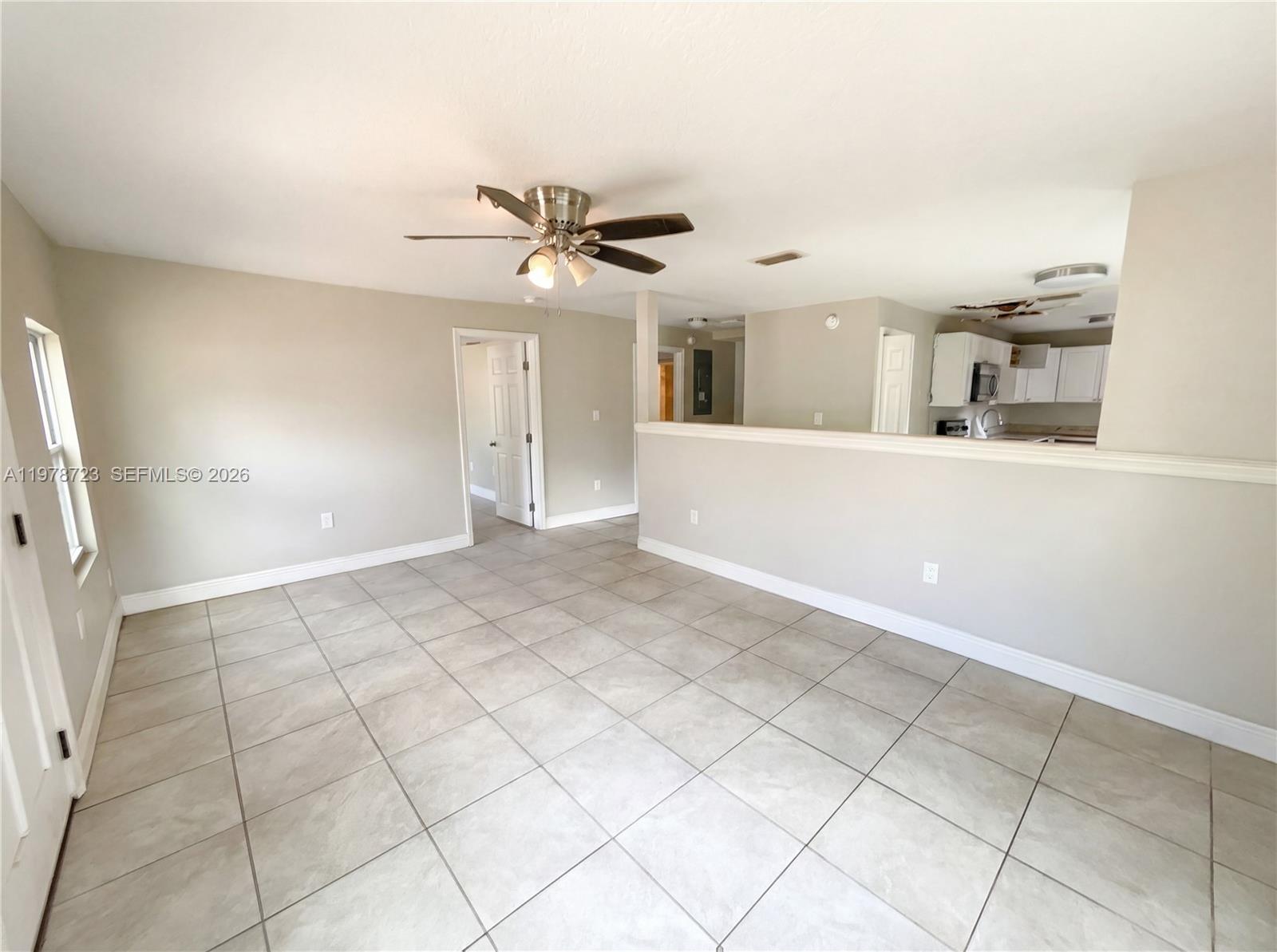 An open-concept living area features light-colored tile flooring, a ceiling fan, and a partial wall — 244 S Rhodes, Mount Dora FL 32757, MOUNT DORA, FL
