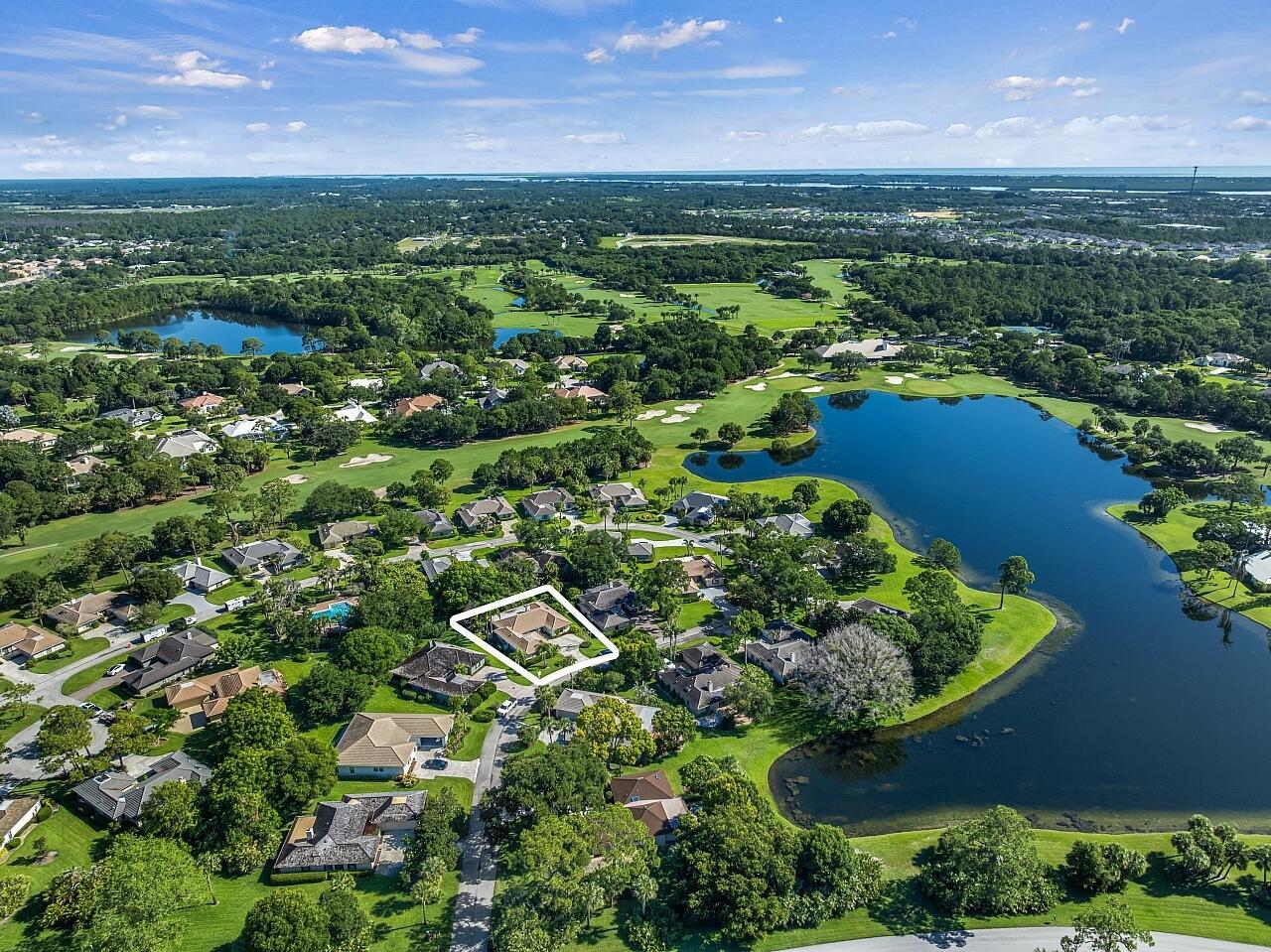 An aerial view shows a residential house highlighted within a golf course community — VERO BEACH, FL