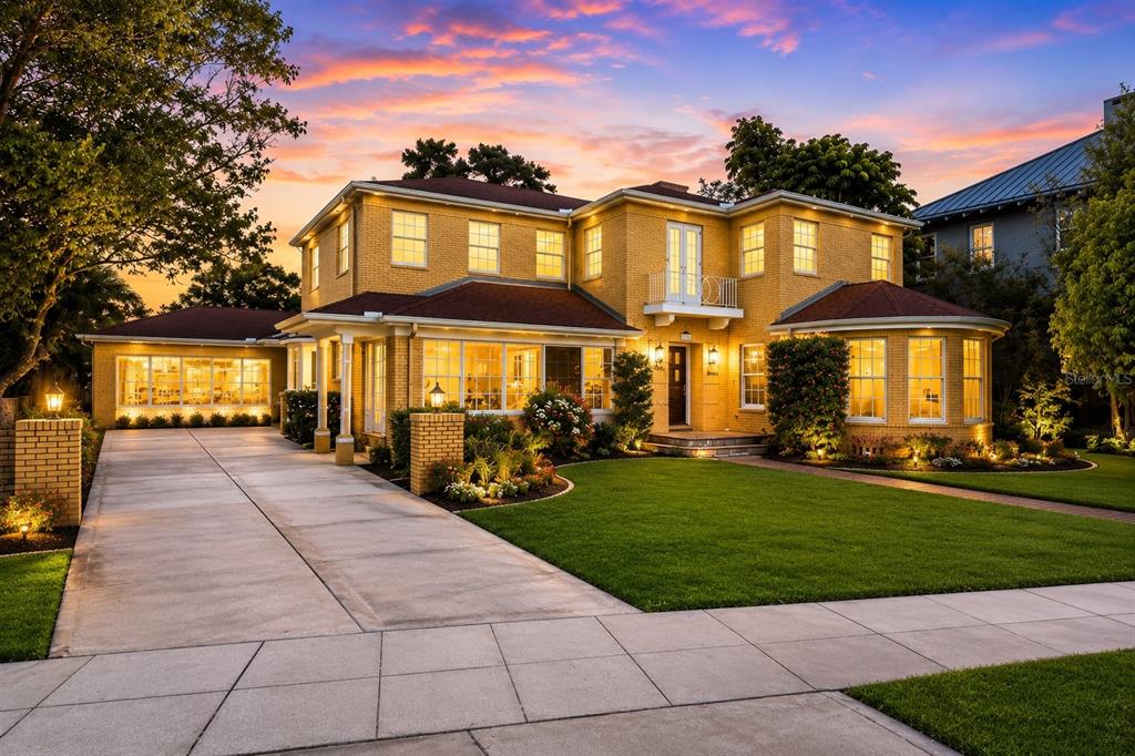 A two-story yellow brick house with a driveway and a landscaped front lawn at sunset — 803 BAYSHORE BOULEVARD, TAMPA, FL
