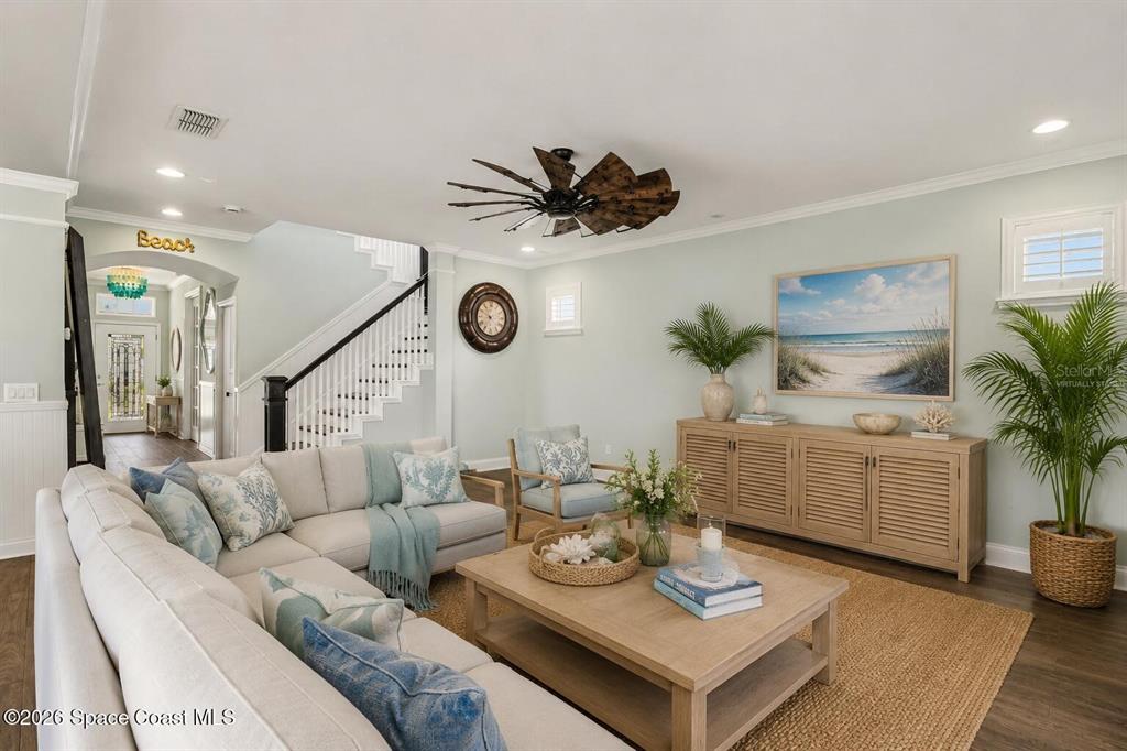 A living room features a large sectional sofa, a coffee table, and a staircase — 10651 LANGEFIELD STREET, ORLANDO, FL