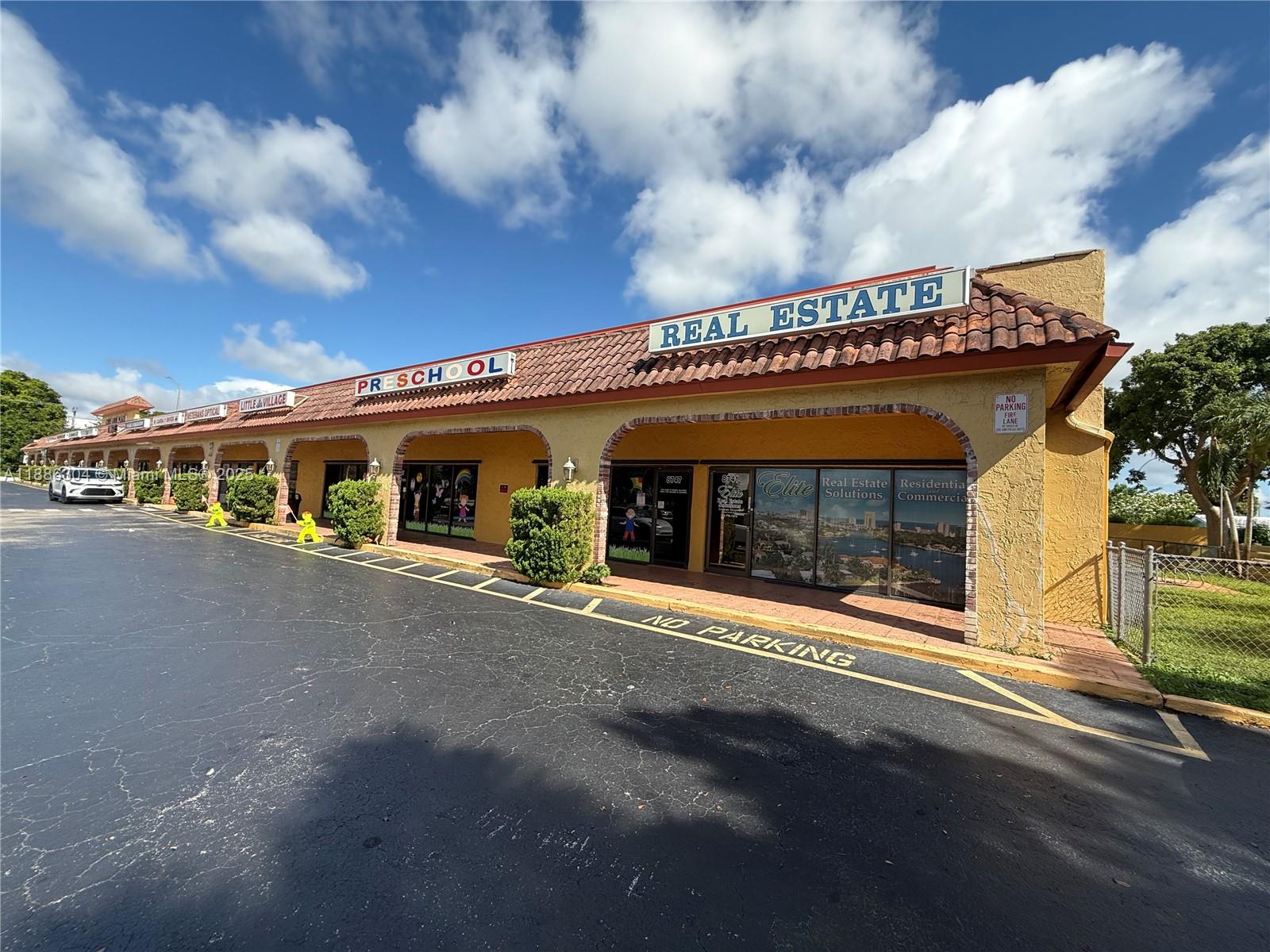 A low-rise commercial strip mall with a tiled roof and a large parking lot — 8741 NW 57th St, Tamarac FL 33351, TAMARAC, FL