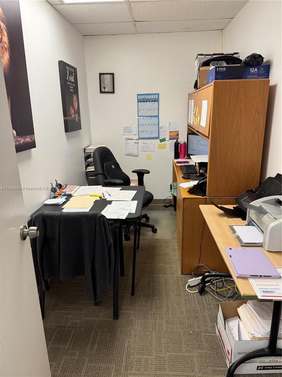 A small office features a desk, a wooden hutch, a printer, and a wall calendar — 8741 NW 57th St, Tamarac FL 33351, TAMARAC, FL