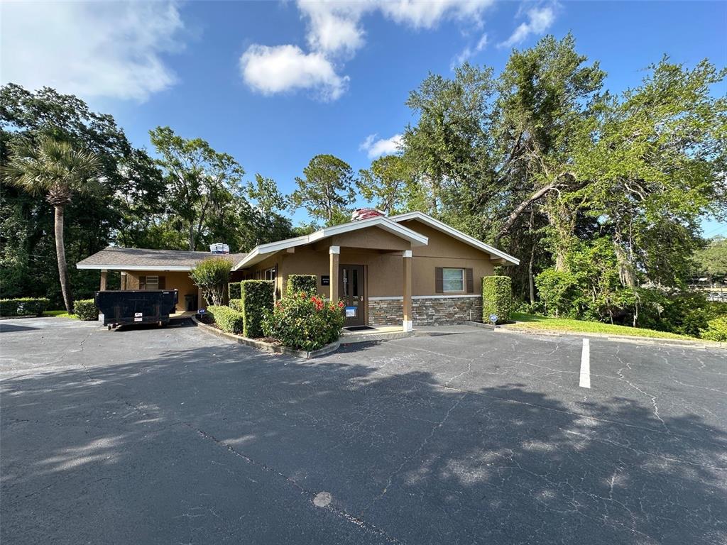 A single-story commercial building with a brown exterior, stone accents, and an adjacent parking lot — 502 E AIRPORT BOULEVARD, SANFORD, FL