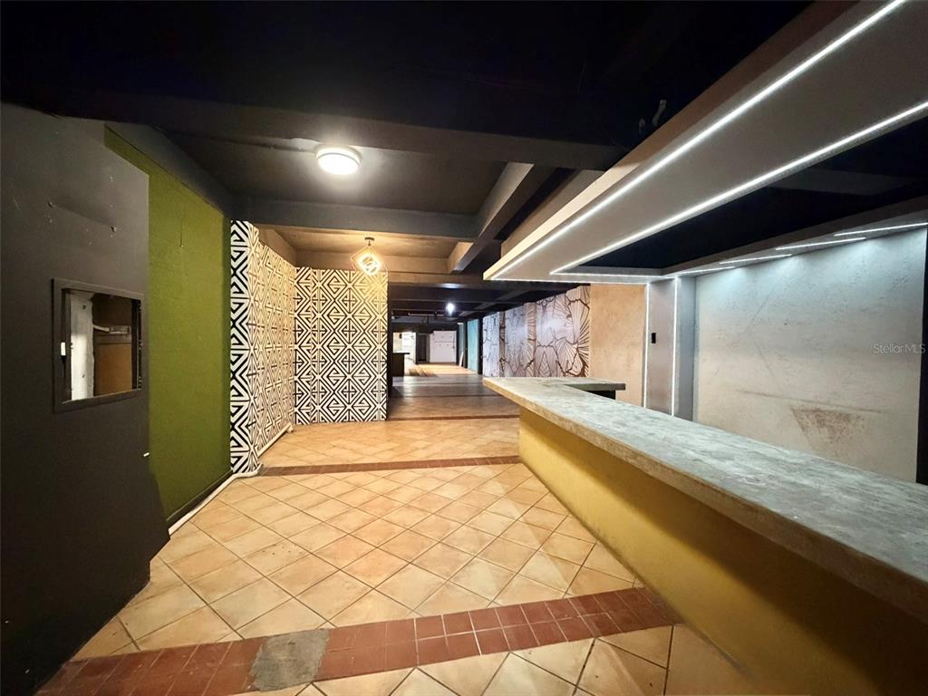 A long, narrow room features a bar counter, tiled flooring, and patterned accent walls — 1204 PONCE DE LEON AVENUE UNIT LOCAL A, SAN JUAN, PR