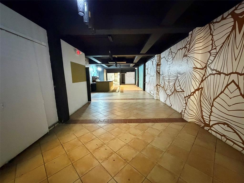 An interior view of a commercial space featuring tiled floors and a large leaf-patterned mural — 1204 PONCE DE LEON AVENUE UNIT LOCAL A, SAN JUAN, PR