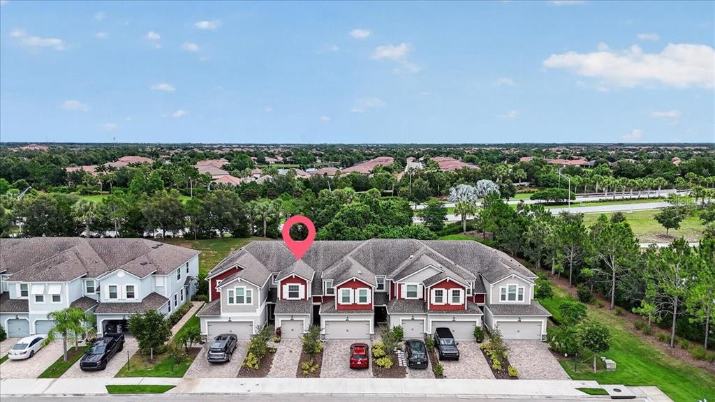An aerial view of a multi-unit townhouse complex with attached garages and paved driveways — 5057 SKYVIEW LANE, BRADENTON, FL