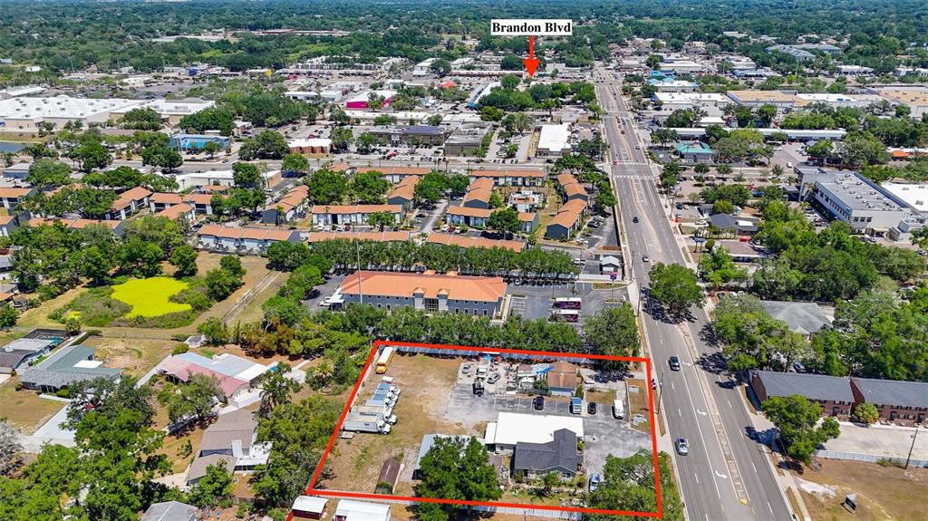 An aerial view shows a rectangular lot with a building and vehicles near a road — 504 S KINGS AVENUE, BRANDON, FL