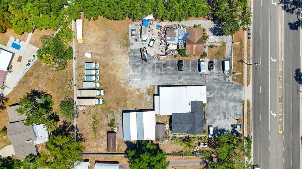 An aerial view shows a commercial property with a parking lot, buildings, and several vehicles — 504 S KINGS AVENUE, BRANDON, FL
