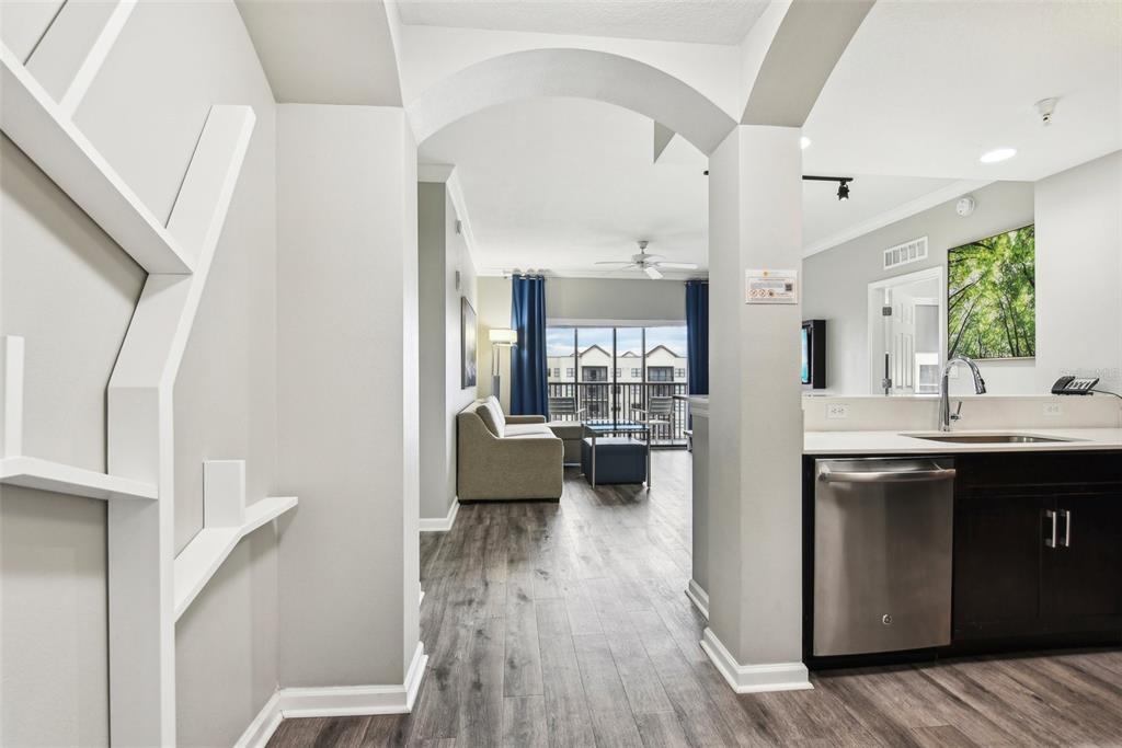 A view from a kitchen area looking through an arched doorway into a living room — 14501 GROVE RESORT AVENUE UNIT 1746, WINTER GARDEN, FL