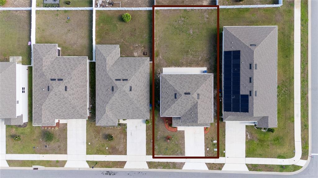 An aerial view shows a single-family home with a fenced backyard highlighted by a border — 339 LAKE SMART CIRCLE, WINTER HAVEN, FL