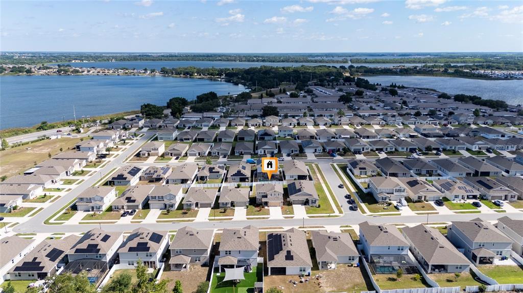An aerial view shows a suburban neighborhood of single-family homes near a large lake — 339 LAKE SMART CIRCLE, WINTER HAVEN, FL