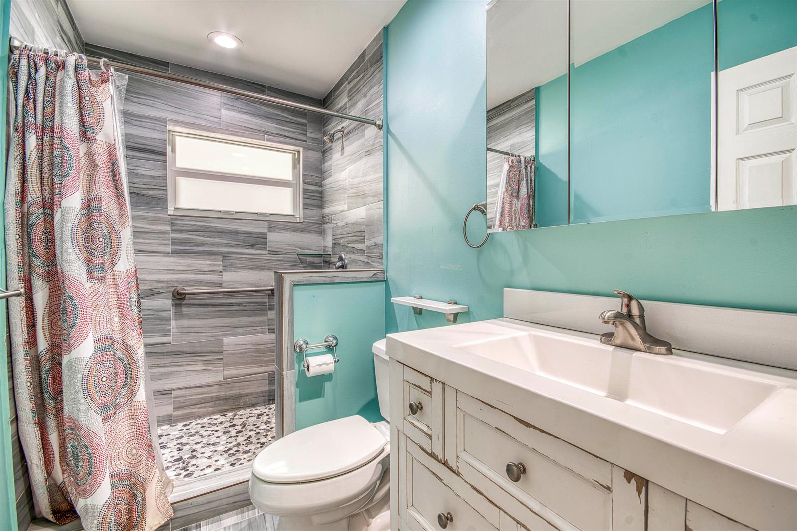 A bathroom features a walk-in shower with gray tile, a white vanity, and turquoise walls — 11065 164th Court N, Jupiter FL 33478, JUPITER, FL