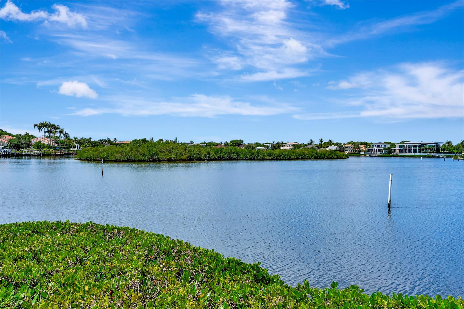 A view of a calm bay with a mangrove island and waterfront homes in distance — 2704 Captains Way, Jupiter FL 33477, JUPITER, FL