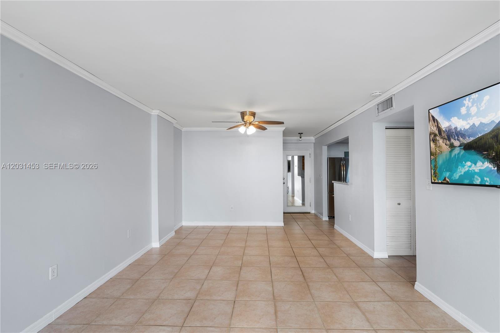 An empty living room features light gray walls, beige tile flooring, and a ceiling fan — 1605 Bay Rd # 503, Miami Beach FL 33139, MIAMI BEACH, FL