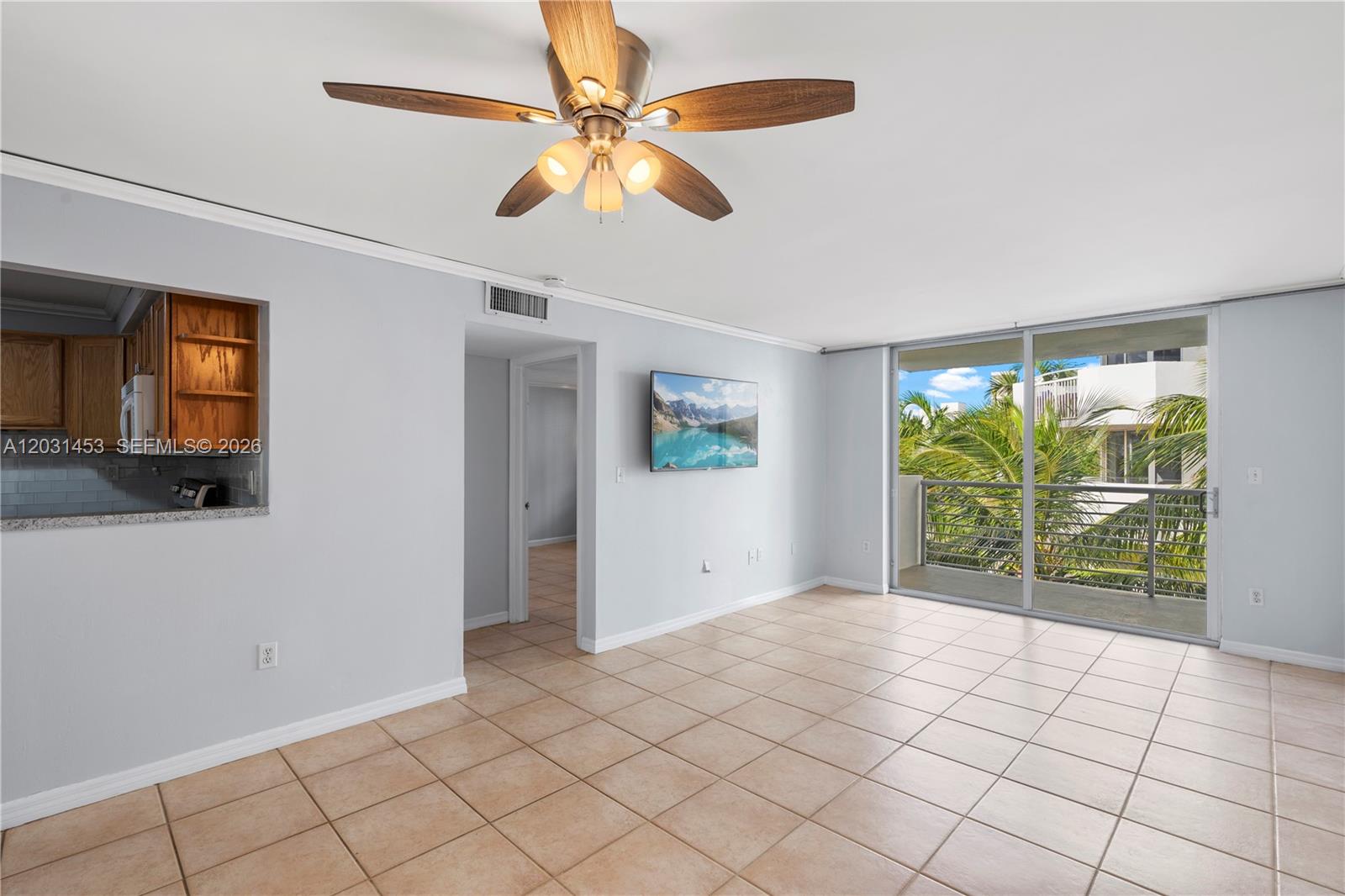 A living room features light tile floors, a ceiling fan, and a sliding glass door — 1605 Bay Rd # 503, Miami Beach FL 33139, MIAMI BEACH, FL