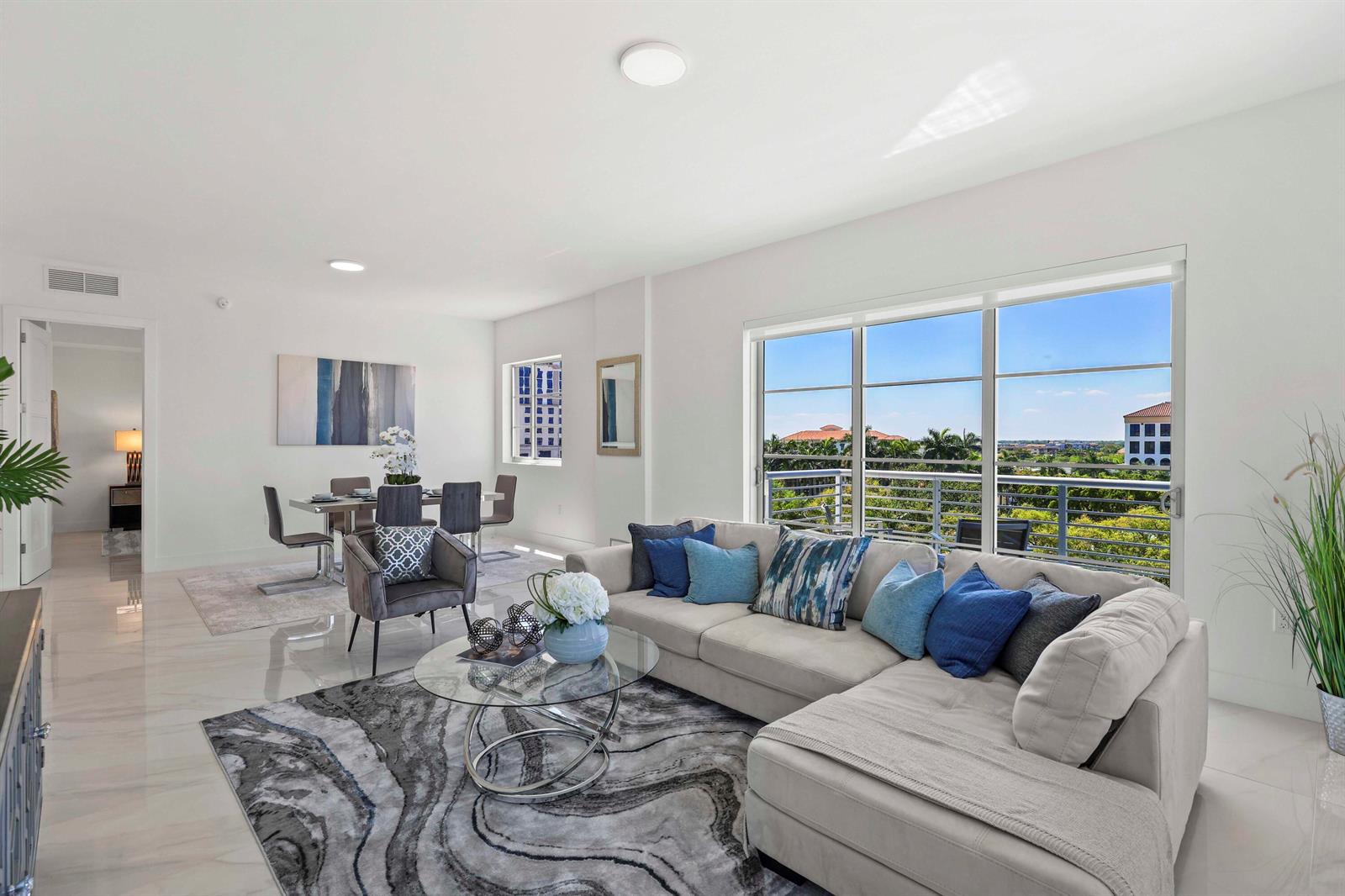A bright living and dining area features a sectional sofa, glass coffee table, and balcony — 155 E Boca Raton Road # 723, Boca Raton FL 33432, BOCA RATON, FL