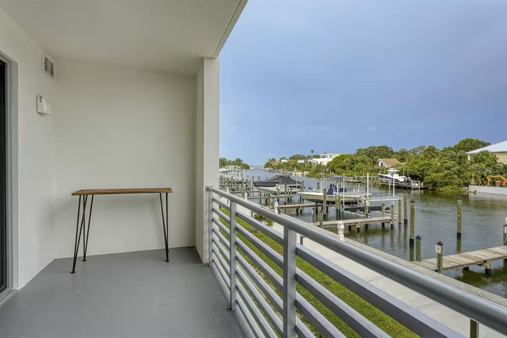 A balcony with a metal railing overlooks a canal with several docked boats — 1709 N TAMIAMI TRAIL UNIT 220, SARASOTA, FL