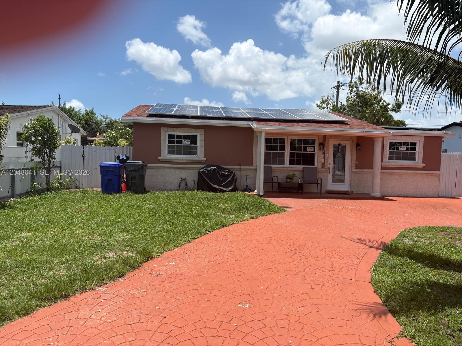 A single-story house with solar panels on the roof and a red stamped concrete driveway — 6444 Fletcher St, Hollywood FL 33023, HOLLYWOOD, FL